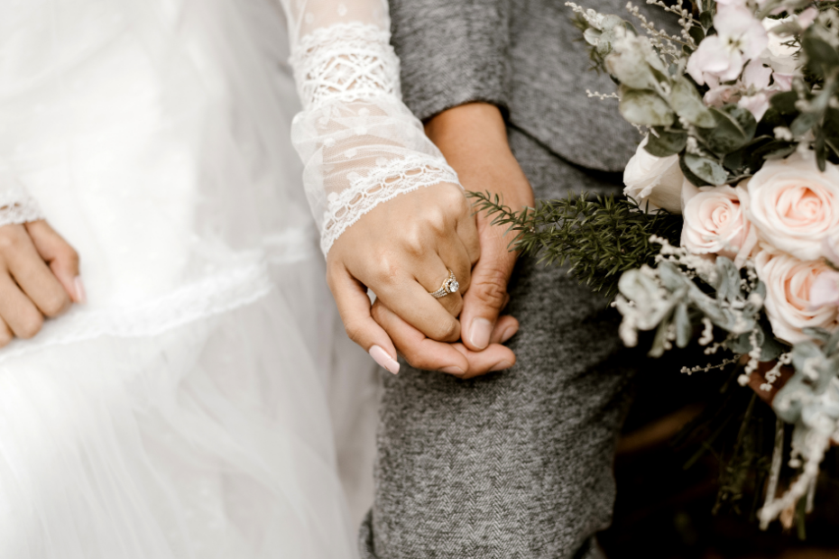 Two people holding hands as a newlywed couple